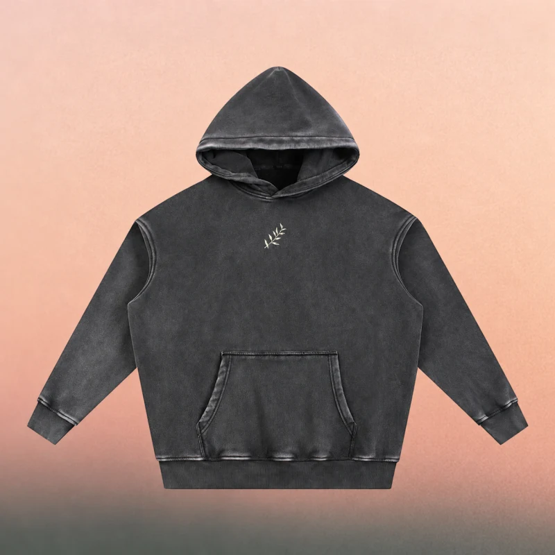 Front mockup — small cream olive branch on the snow-washed black hoodie